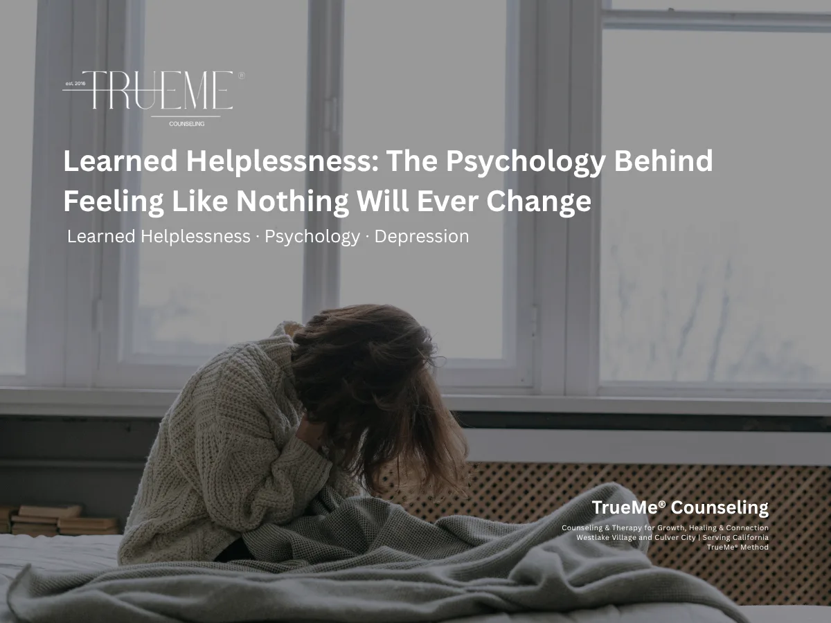 Woman sitting on a bed with head in hands in a sunlit room; overlaid headline about learned helplessness by TrueMe Counseling.