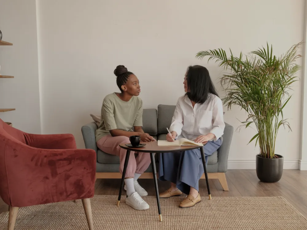 A woman sitting in a couch with a professional therapist.