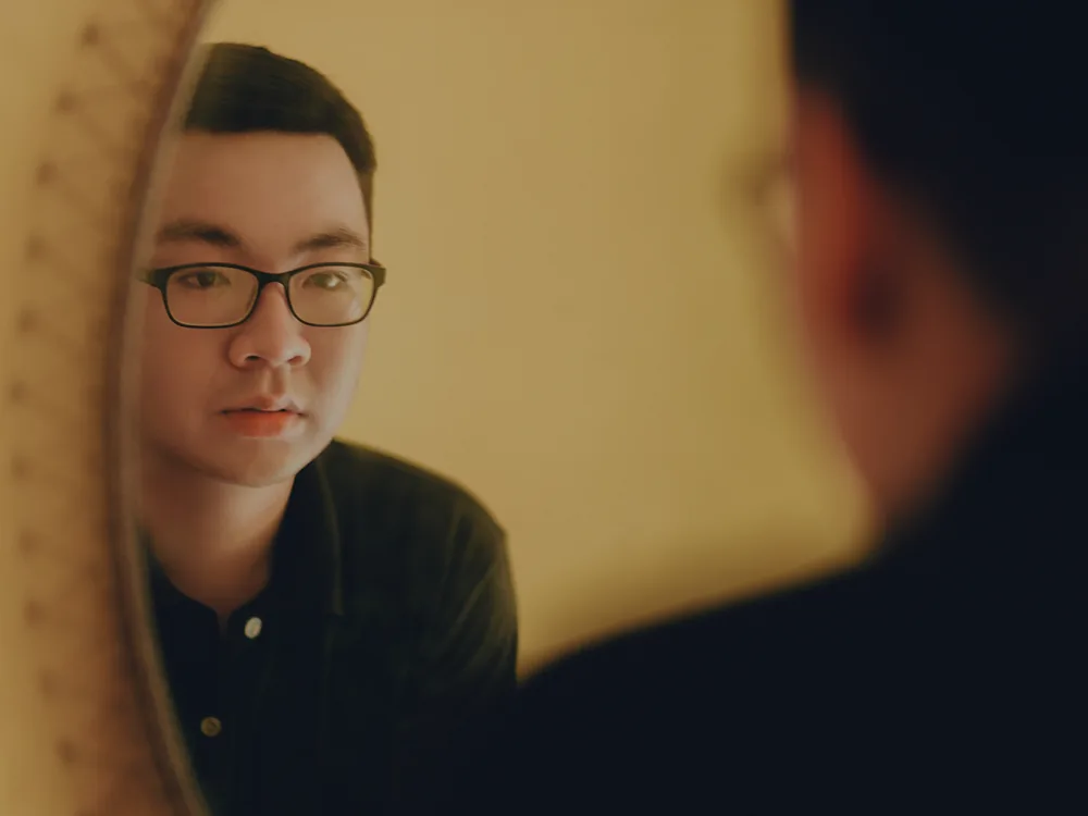 A guy looking at himself in a mirror