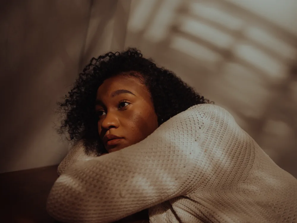 Woman in deep thoughts in a low lit room