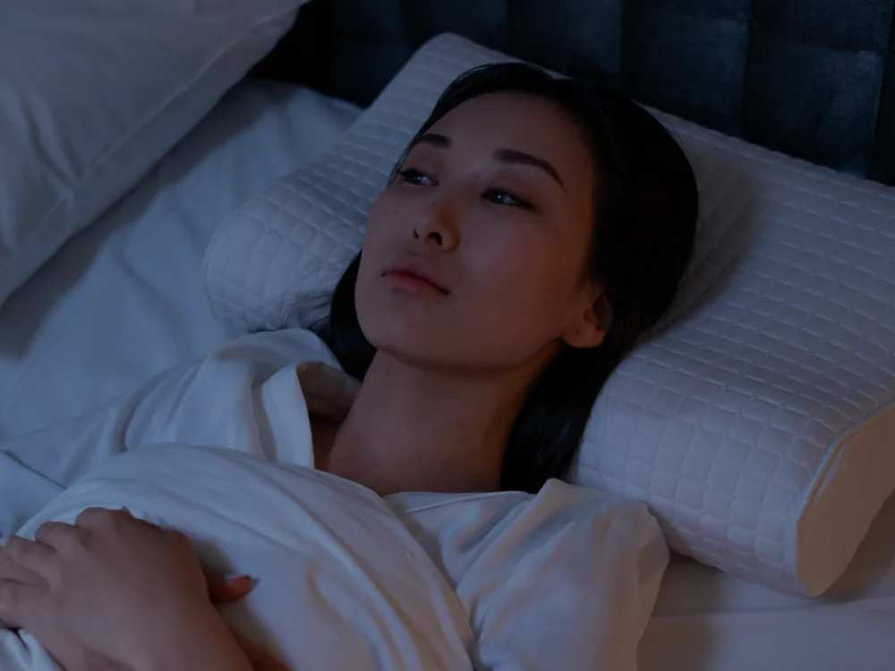 Woman awake in the middle of the night, looks like in deep thoughts